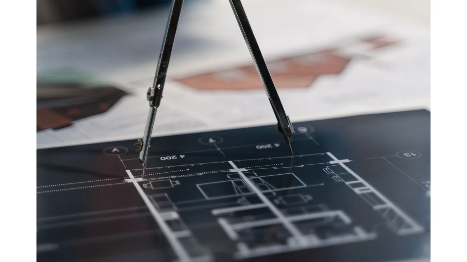 Drawing compass resting on architectural plans