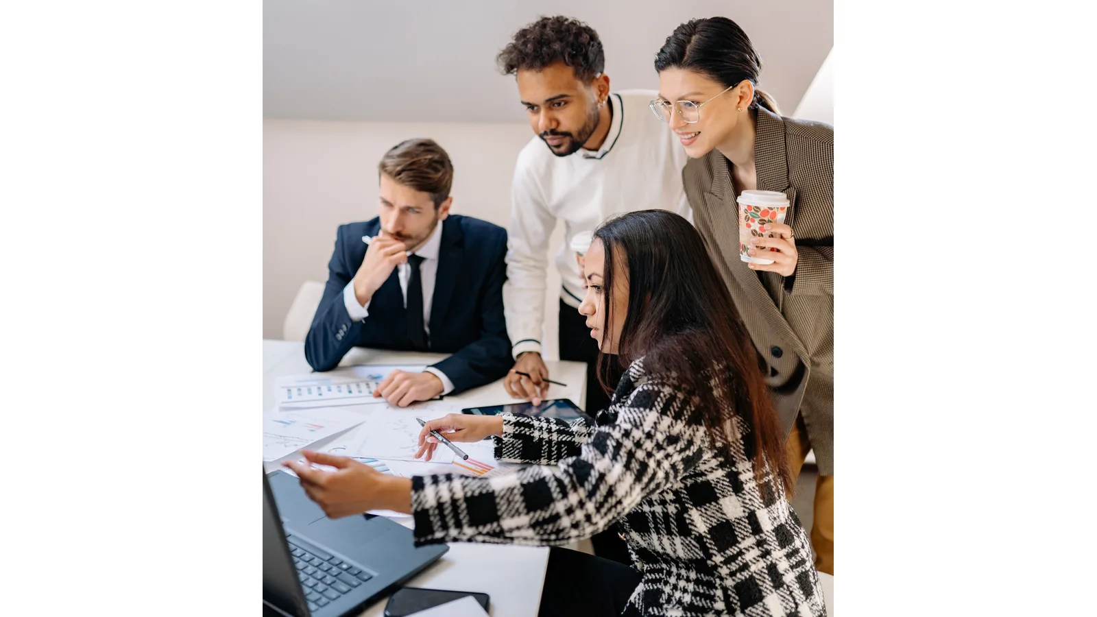 Colleagues reviewing papers together beside a laptop