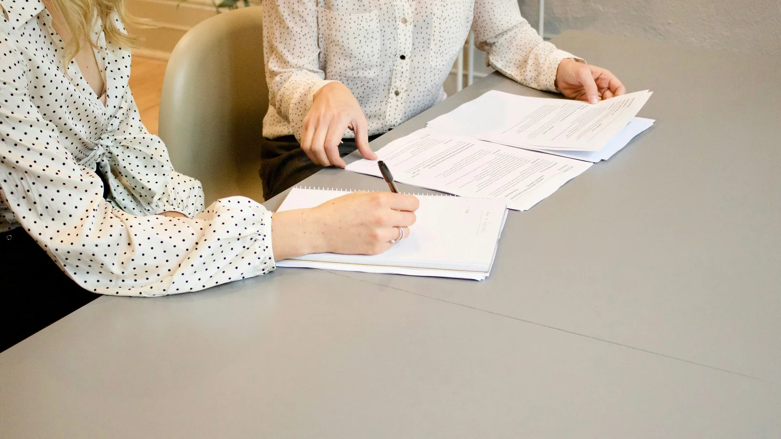 Two people reviewing and signing paperwork
