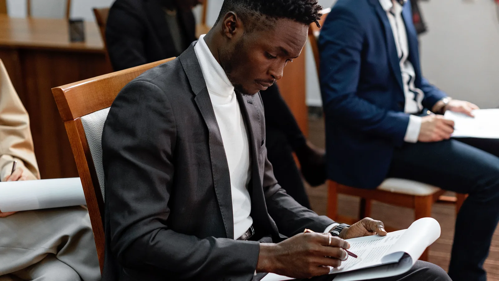 Man writing in a document while seated