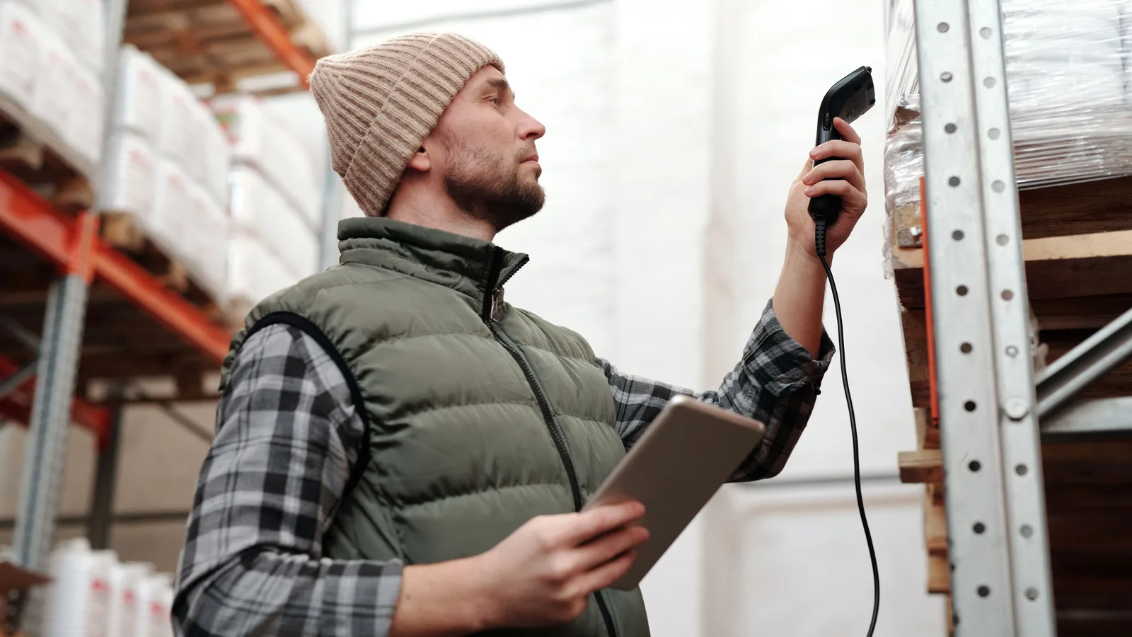 Warehouse worker scanning goods while holding a tablet