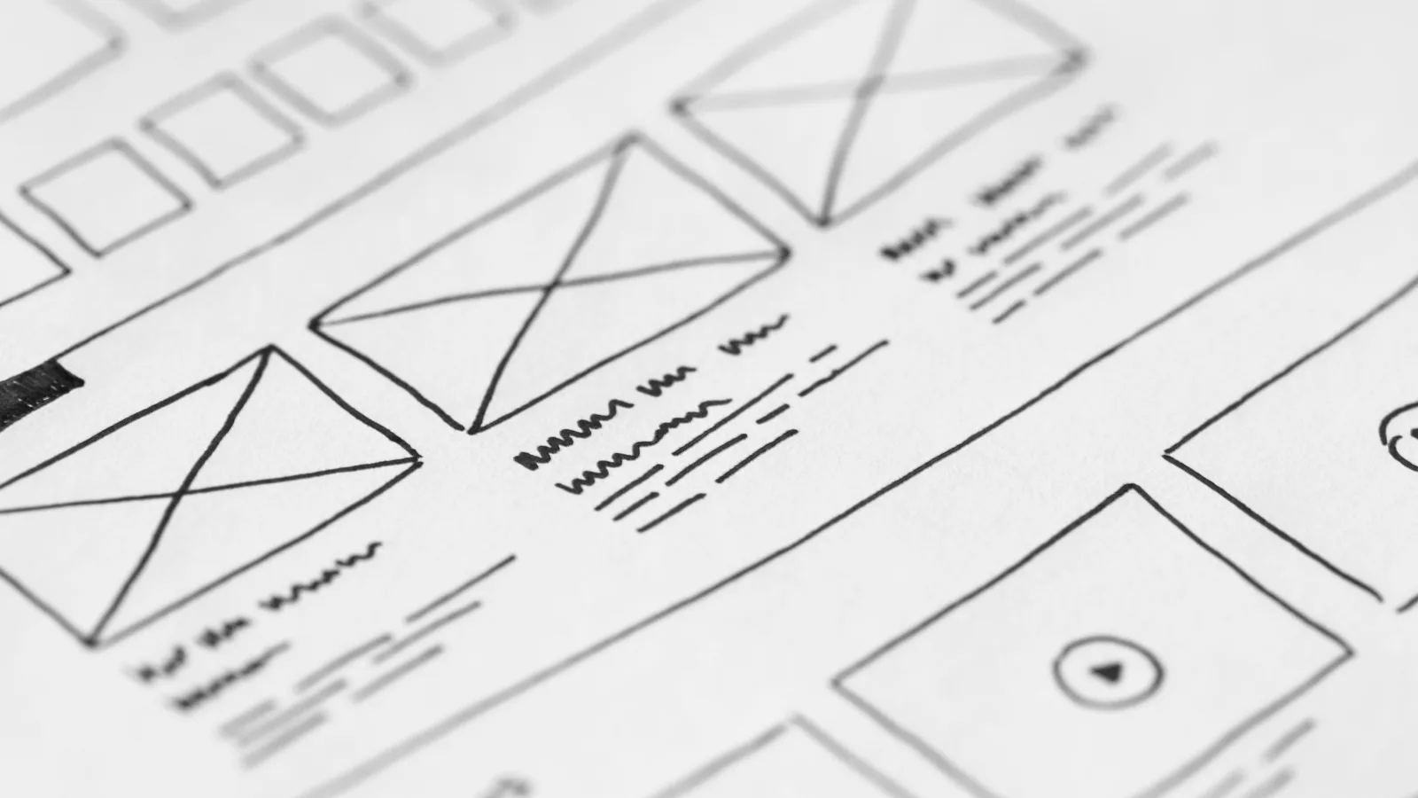 Hand-drawn website wireframes photographed on paper