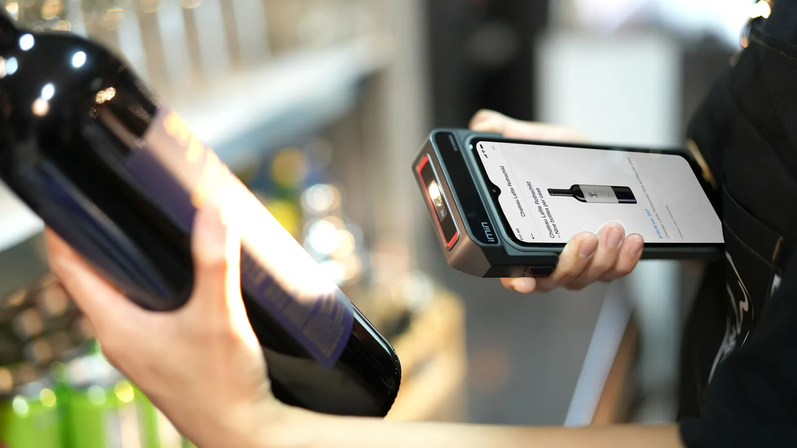 Shop worker scanning a wine bottle with a handheld POS device