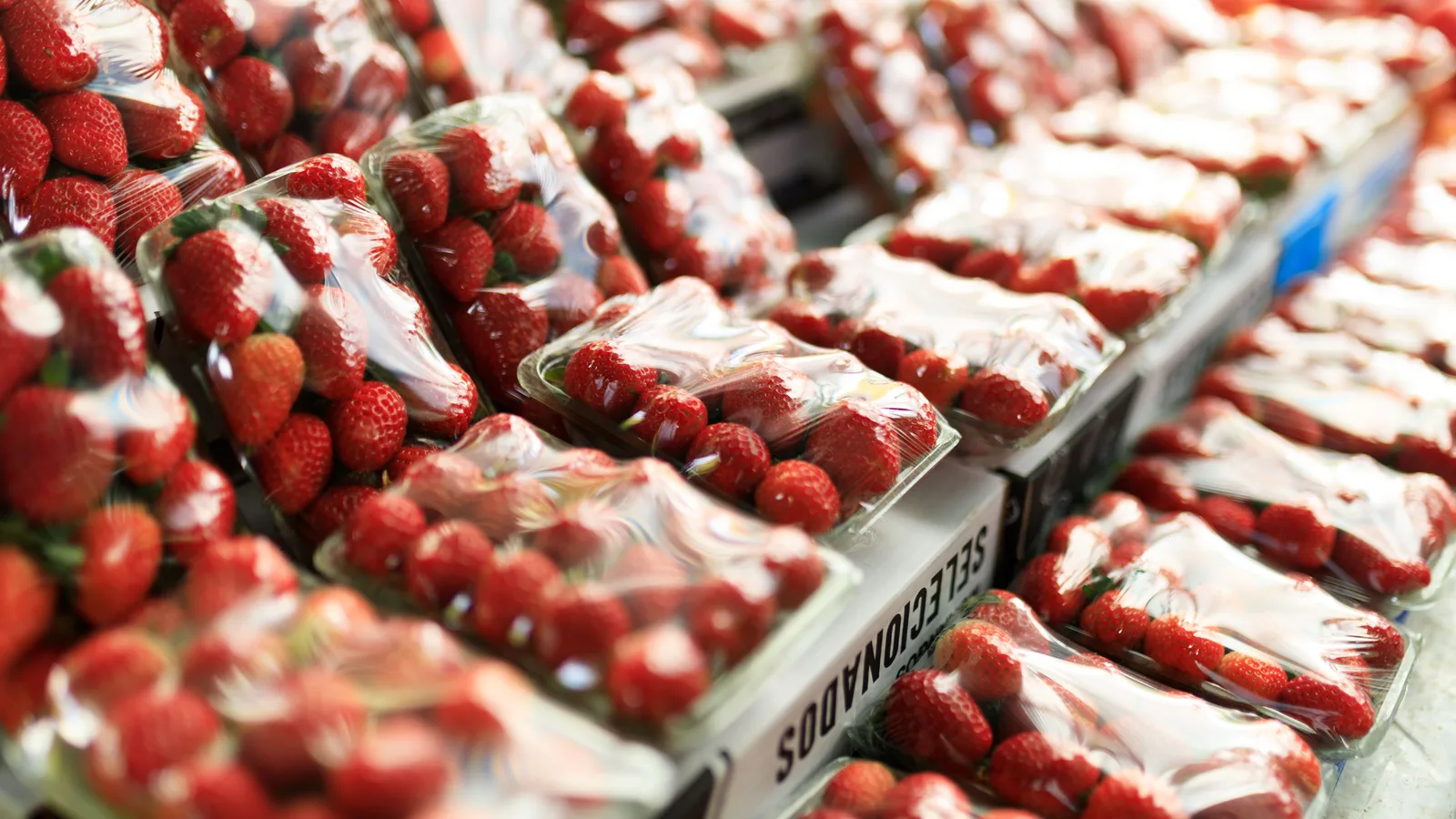 Fresh strawberries packed in clear containers at a market
