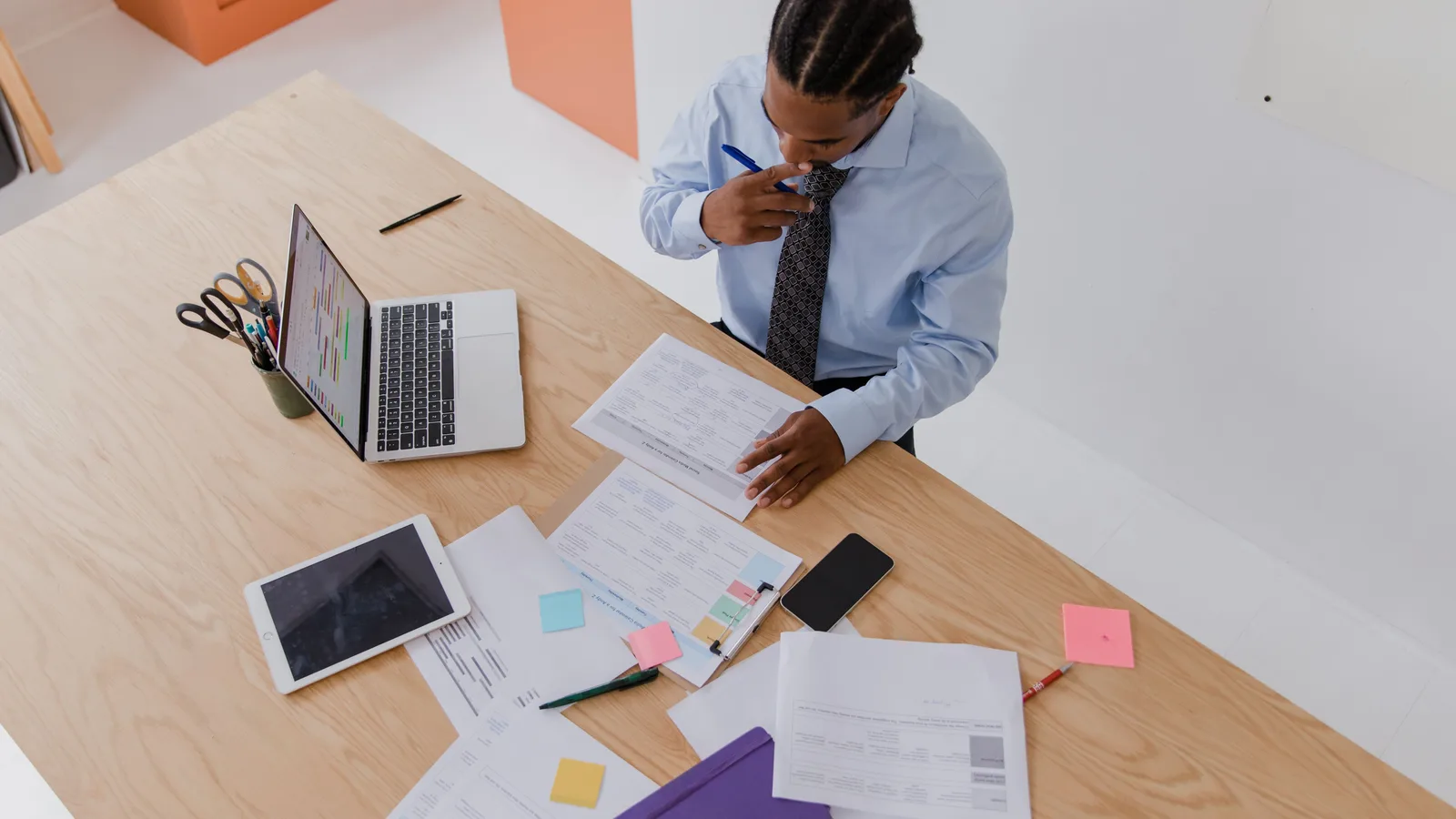 Person reviewing documents beside a laptop