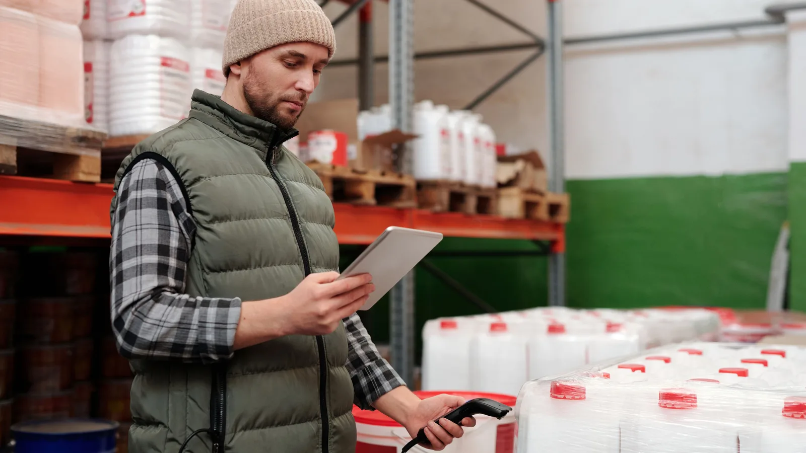 Warehouse worker checking containers with a tablet and scanner