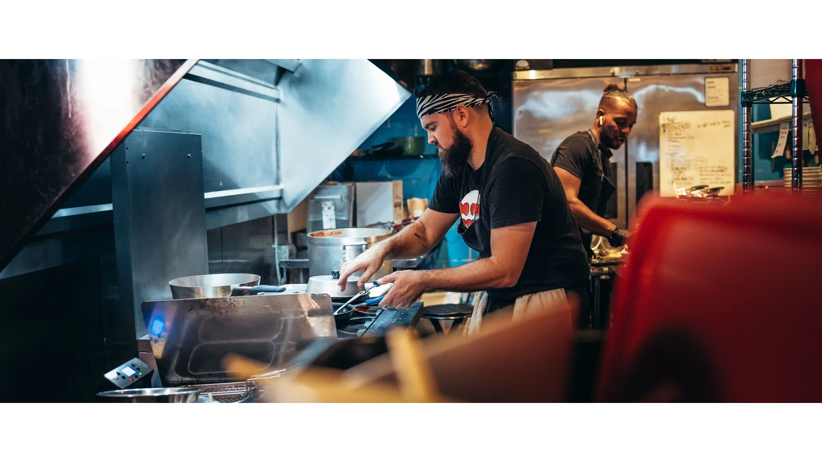 Two cooks working at a restaurant preparation station