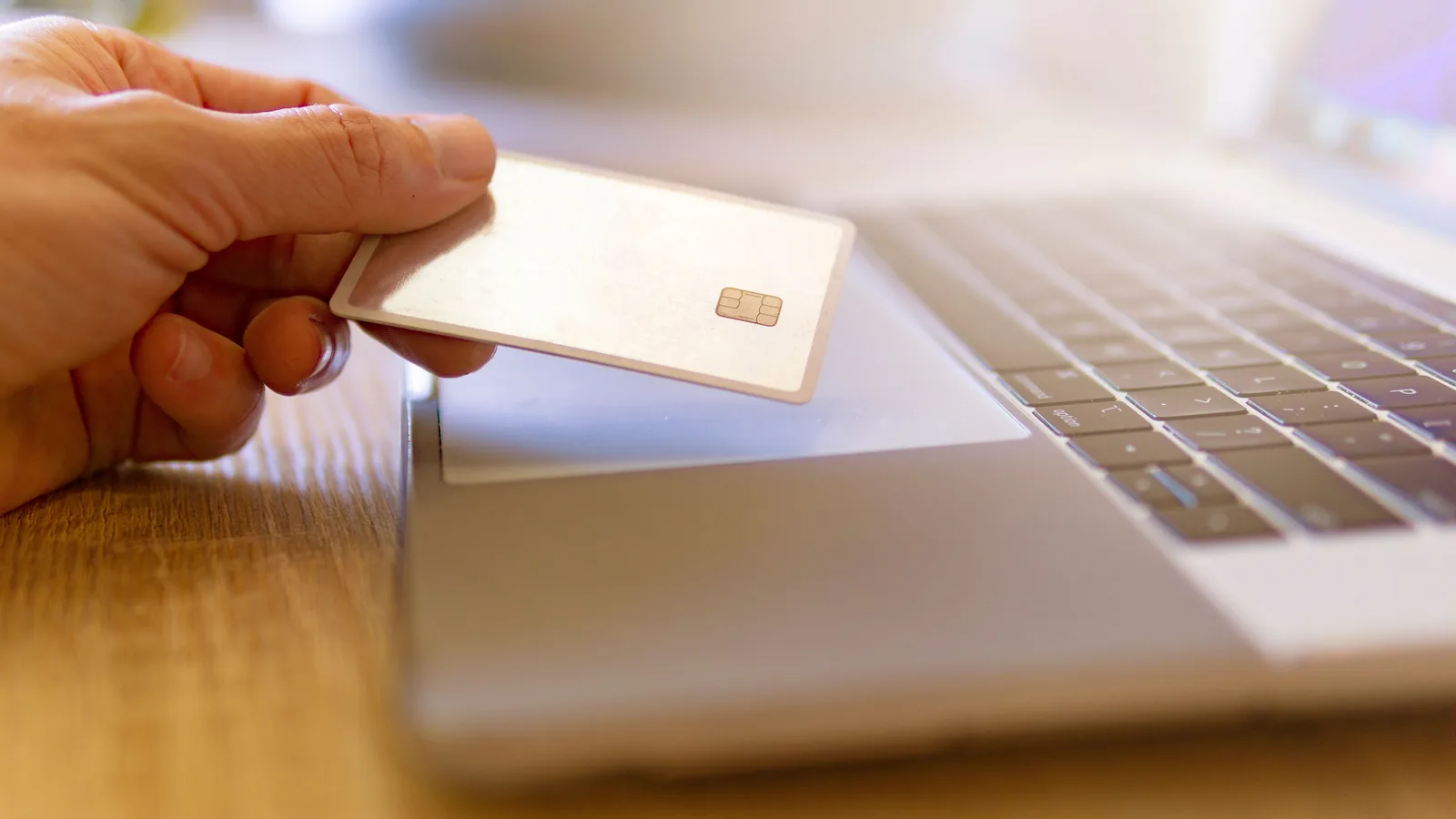 Bank card held above a laptop keyboard