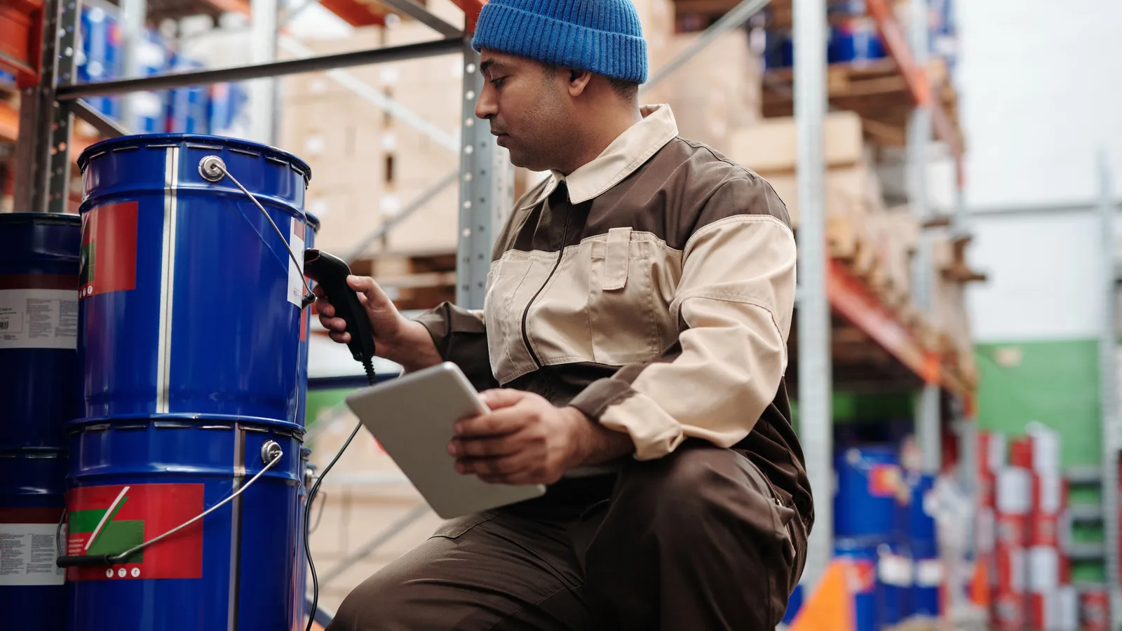 Warehouse worker scanning a stock container while holding a tablet