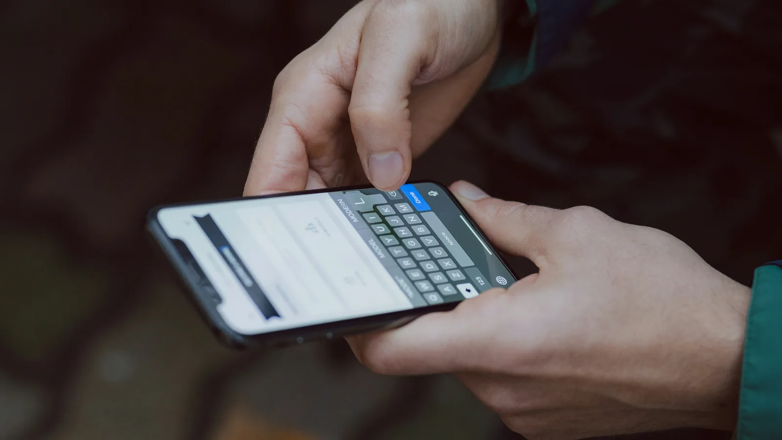 Hands typing a message on a smartphone
