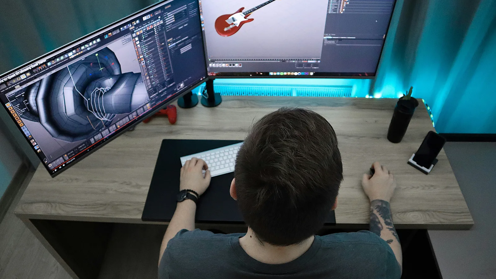 Person working on a three-dimensional guitar model on a monitor