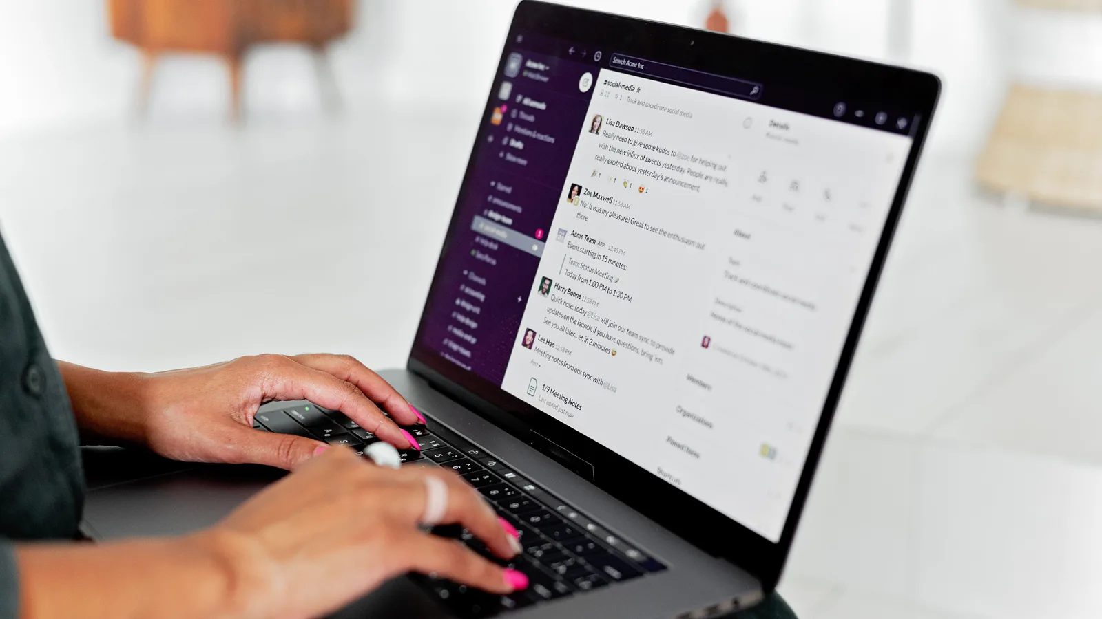 Hands using a laptop displaying a Slack conversation