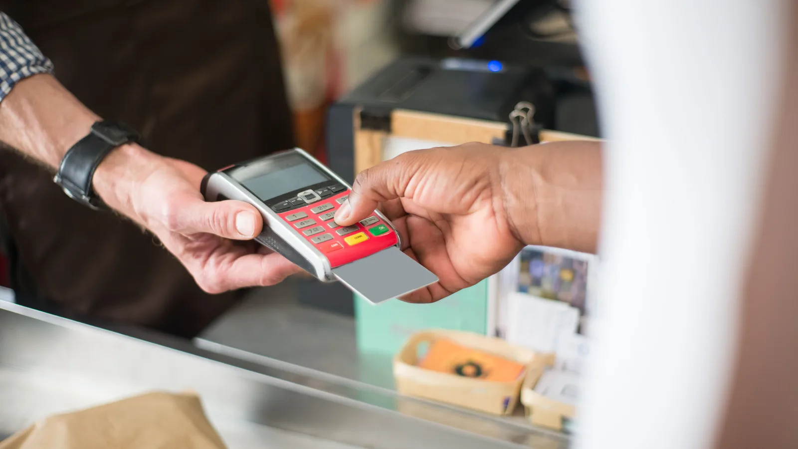 Customer entering details on a handheld payment terminal