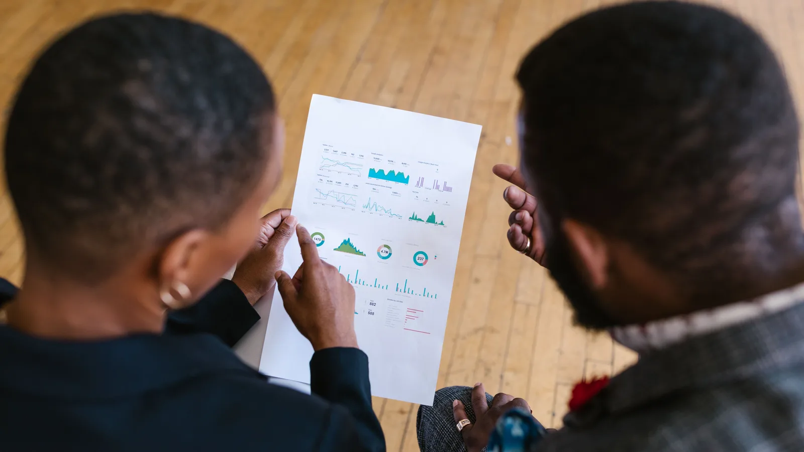 Two people discussing a printed business report