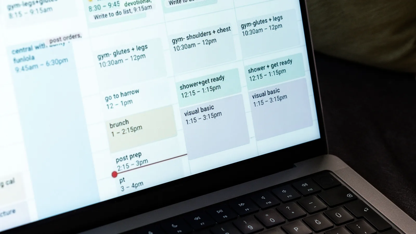 Hands typing beside a digital weekly calendar on a laptop
