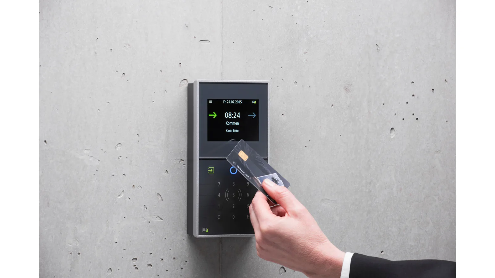 Hand presenting a card to a wall-mounted access reader