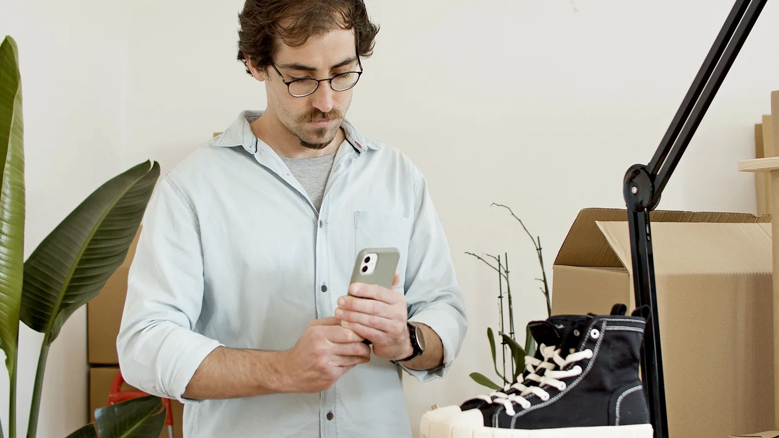 Man photographing a shoe with a smartphone