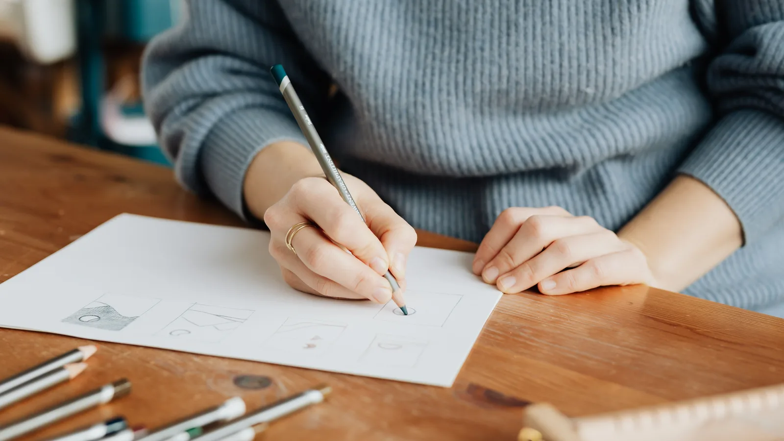 Person sketching geometric logo concepts