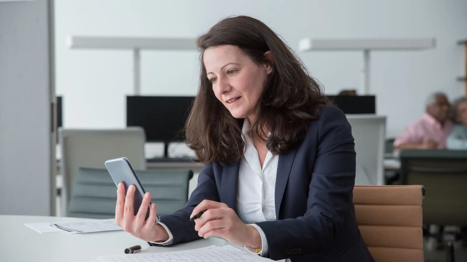 Woman using a smartphone at an office desk