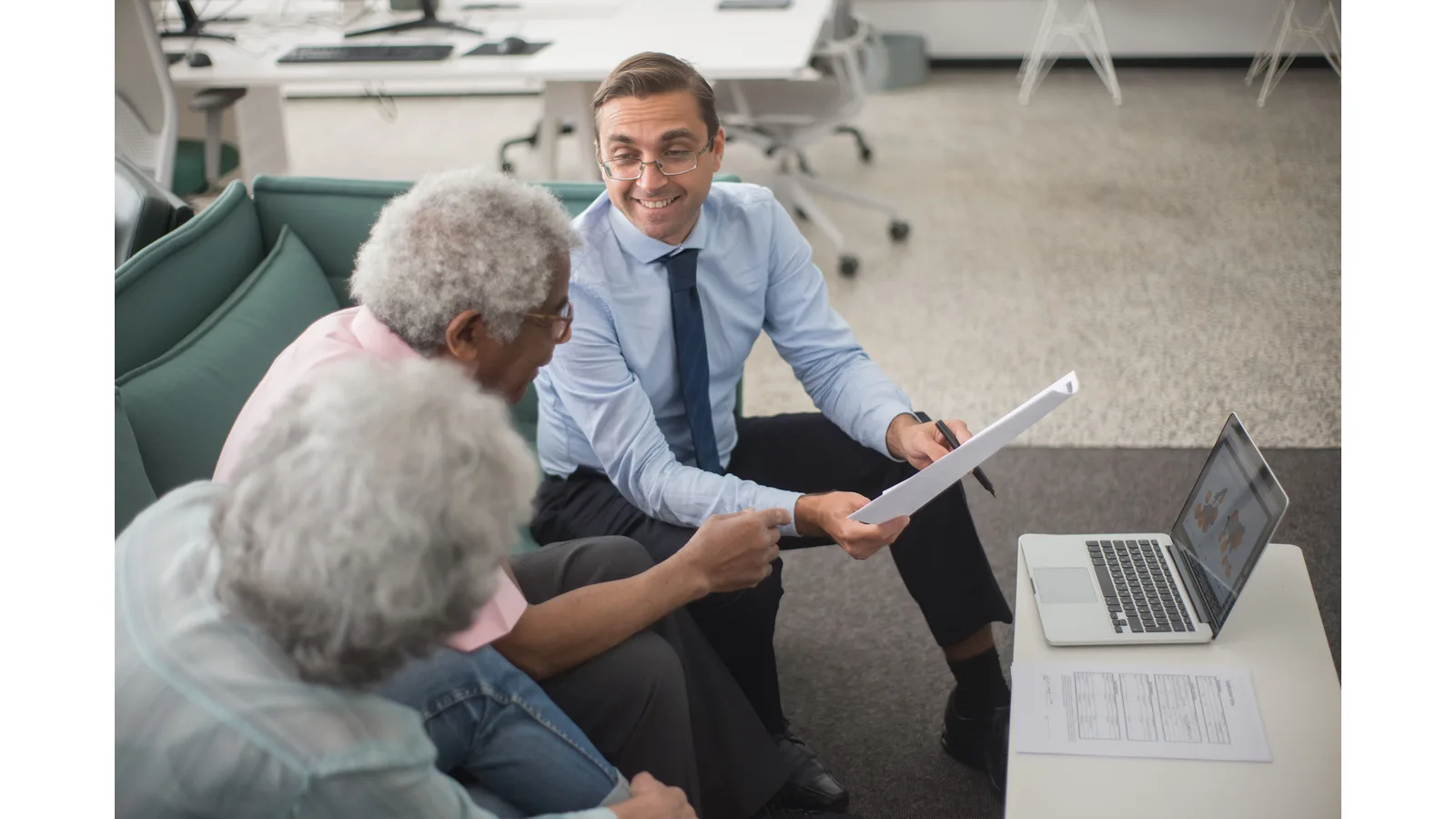 Financial adviser discussing paperwork with two clients