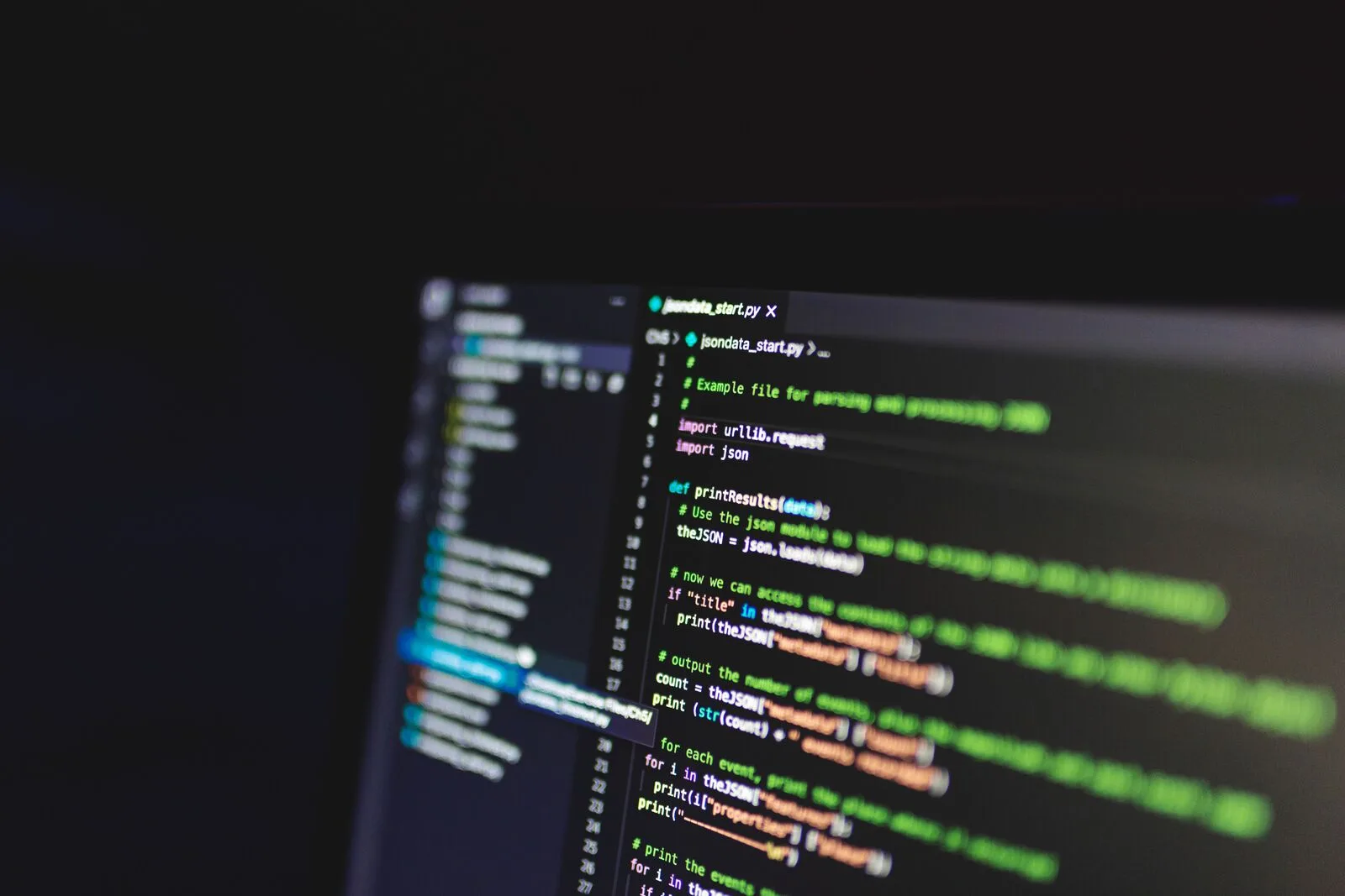 Code on a laptop screen in a dim workspace