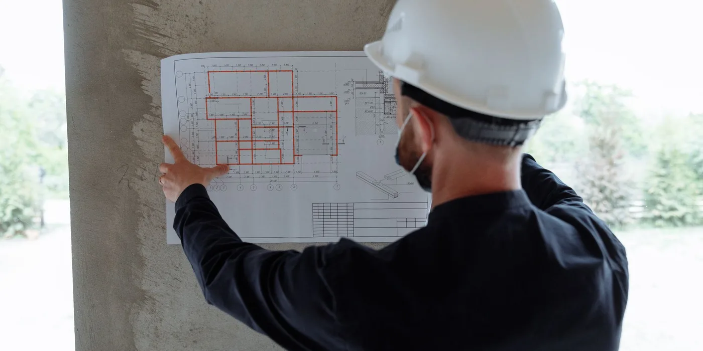 An engineer reviewing building plans on site