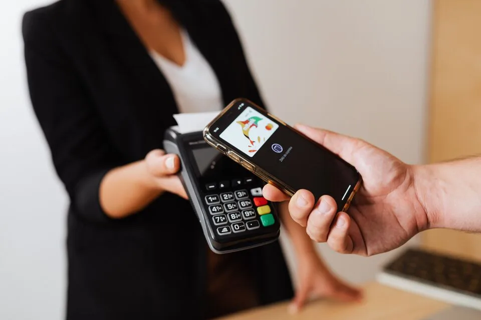 A customer paying by phone at a counter